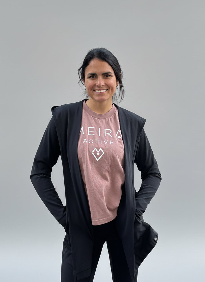 woman wearing activewear consisting of an open cardigan and legging set and Meira Active T-shirt standing against a light grey background