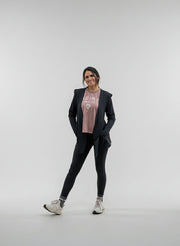 Woman wearing a black open activewear cardigan and activewear leggings on a white background