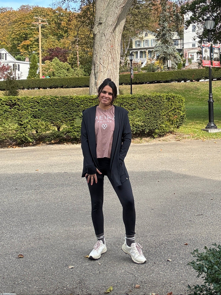 Woman walking in a park and wearing an open activewear cardiga with leggings and a t-shirt